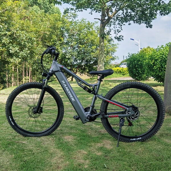Elektrisk mountainbike på gräset bland träden